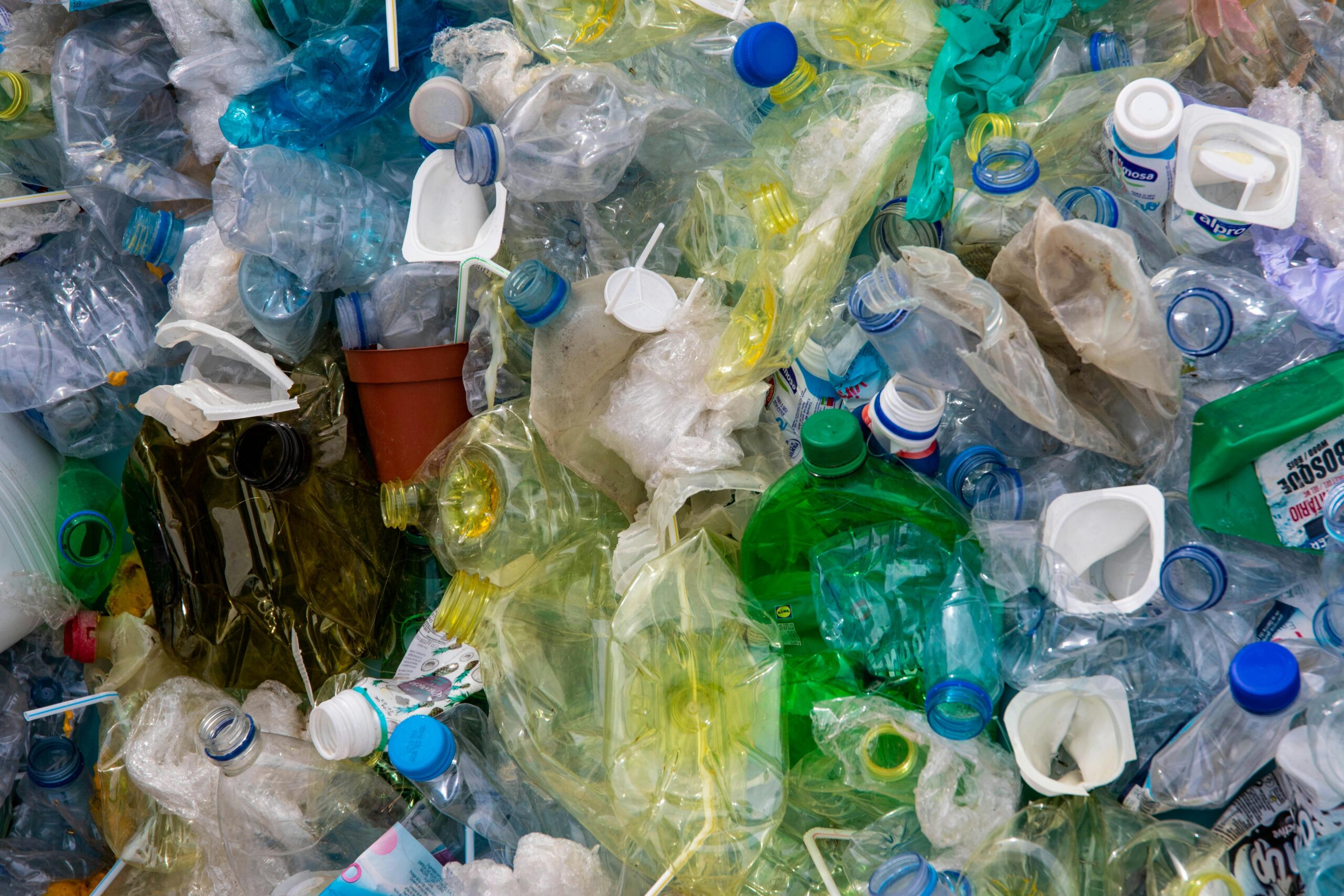 Hand picking up plastic bottle from the beach