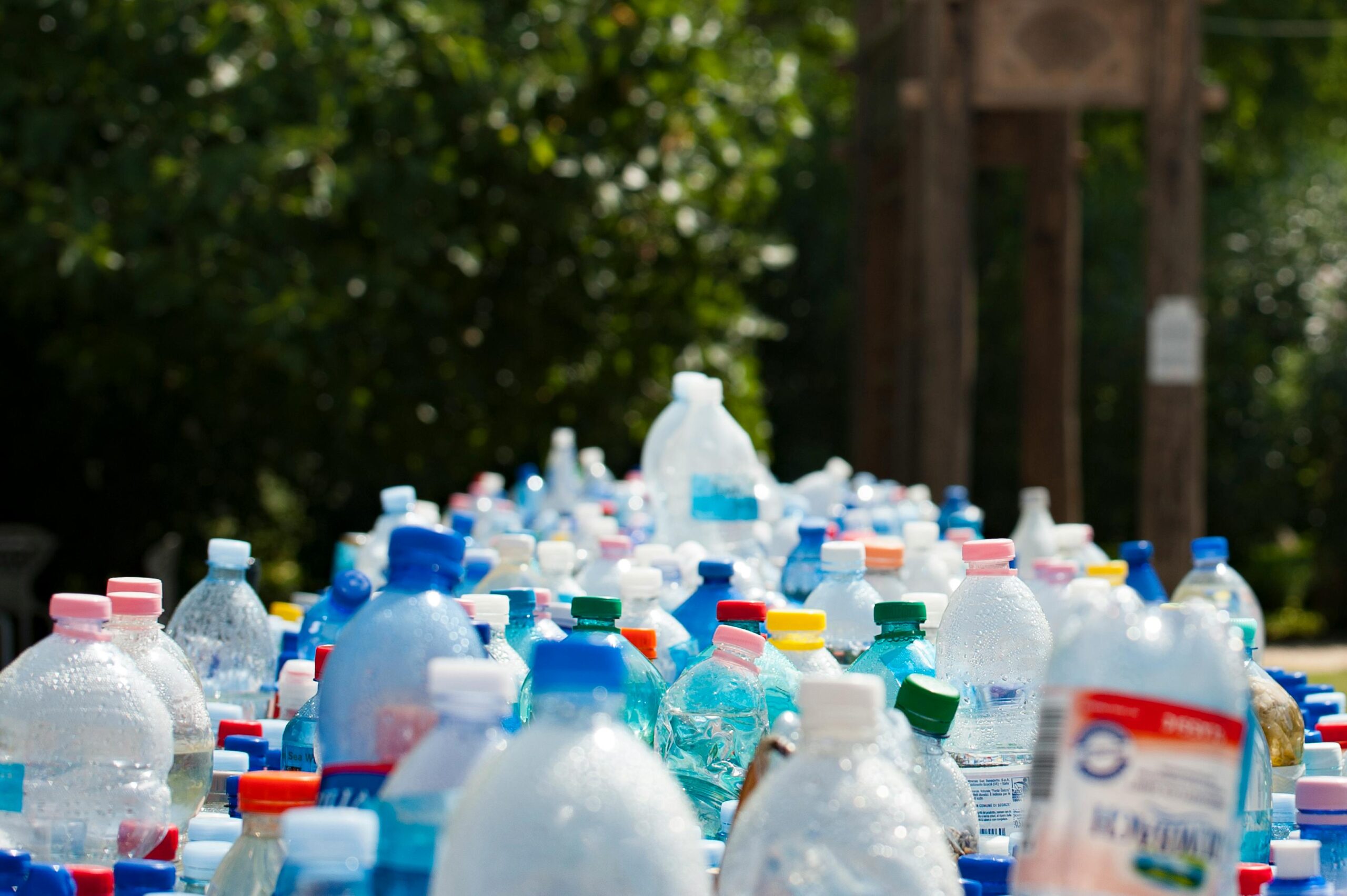 Hand picking up plastic bottle from the beach